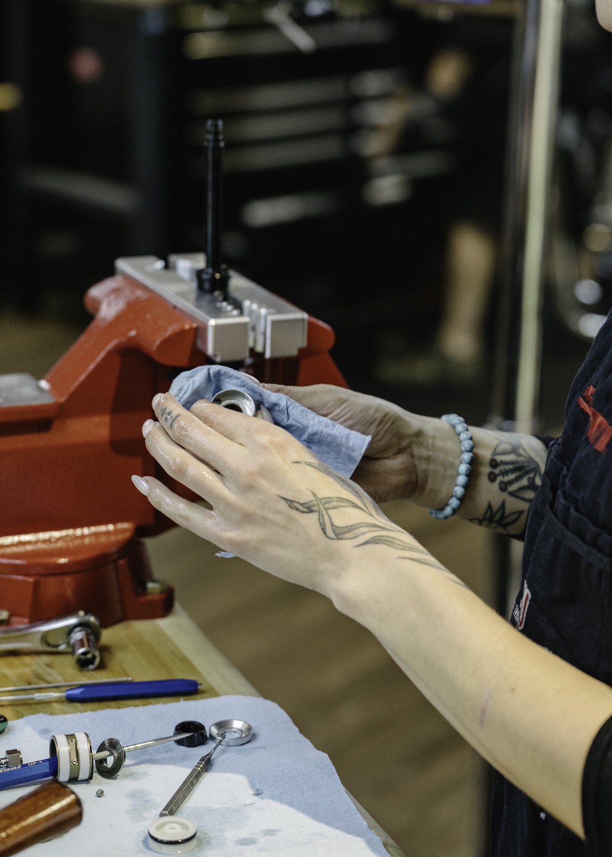 Close view of a mechanic servicing a suspension damper at the bench vise